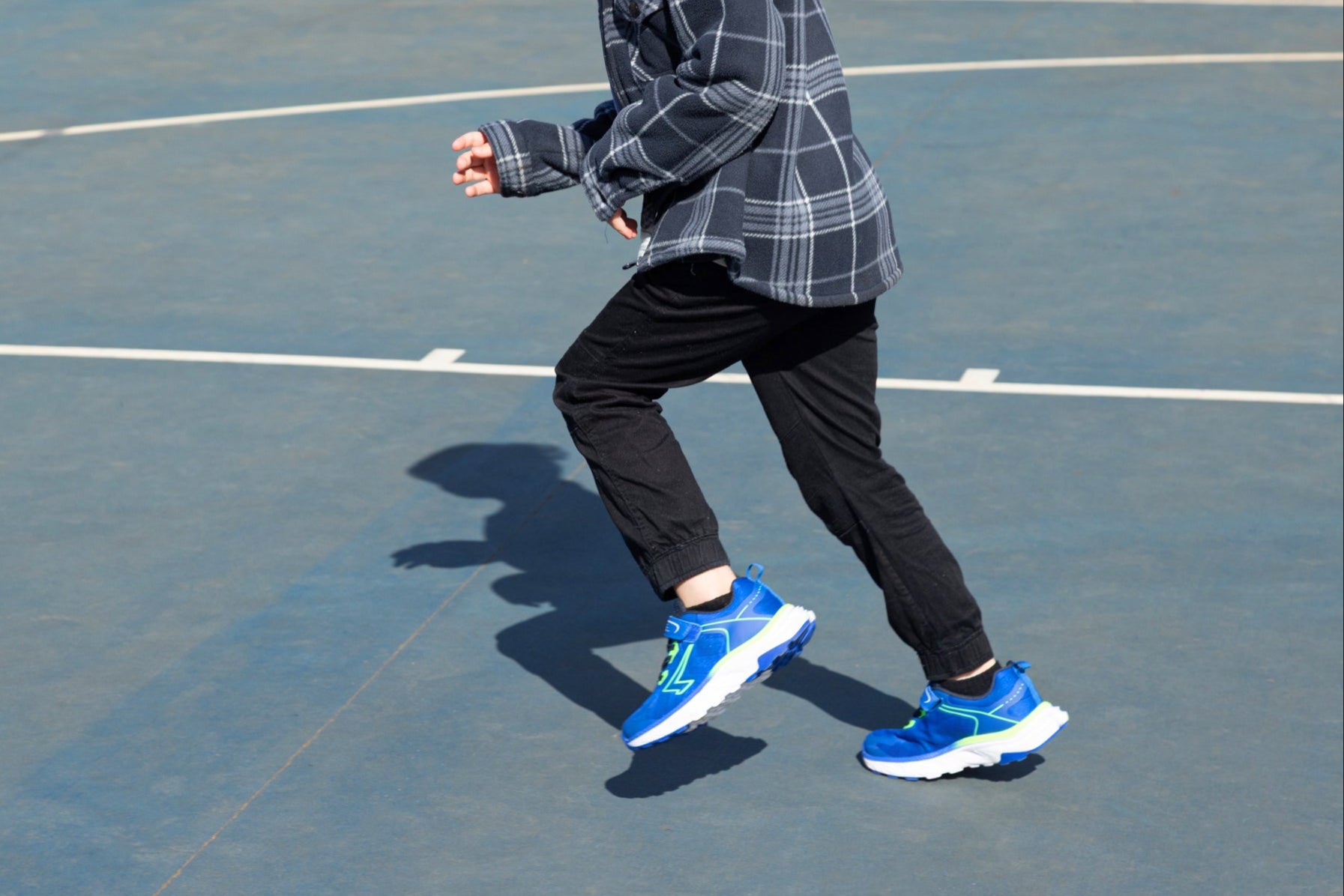 Boy wearing blue sneakers on a tennis court