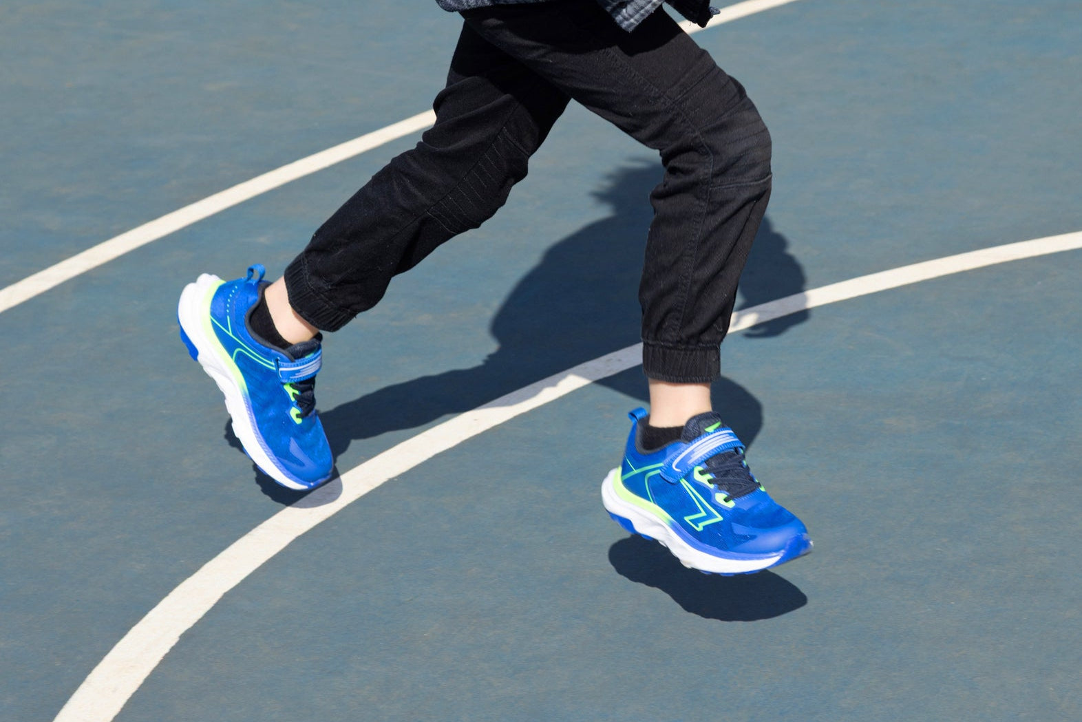 Boy wearing blue athletic shoes on a basketball court
