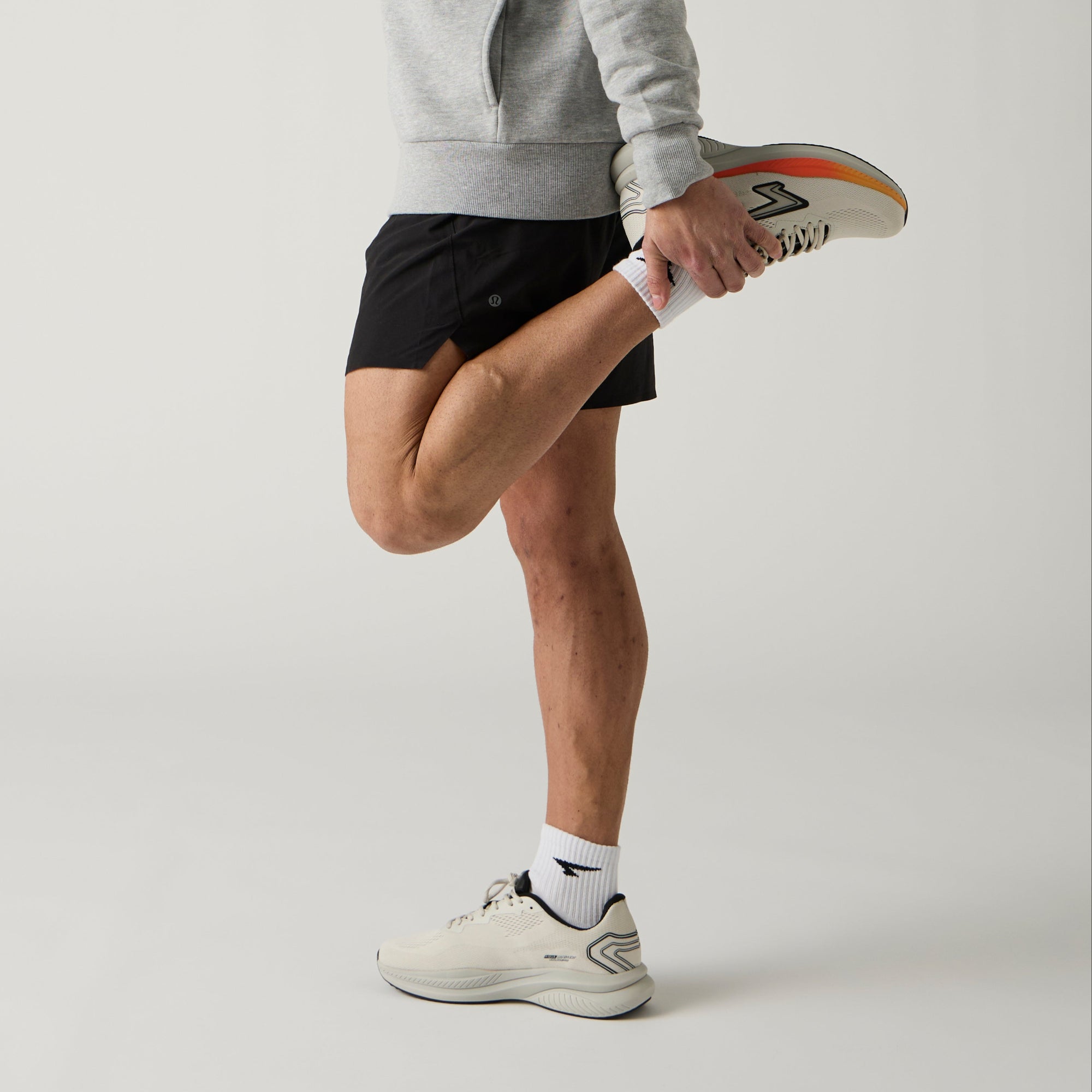 Man stretching his leg on a plain background